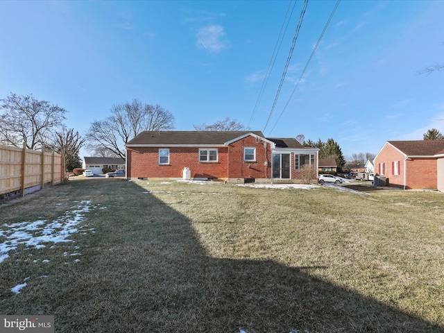 rear view of property with a lawn