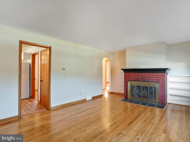 unfurnished living room featuring hardwood / wood-style flooring and a fireplace