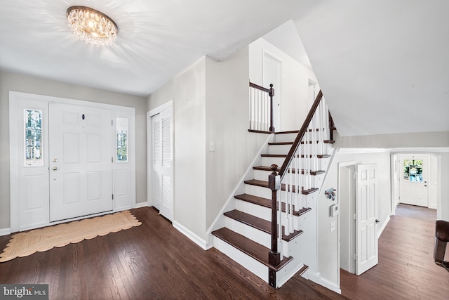 foyer entrance with dark hardwood / wood-style flooring and a notable chandelier