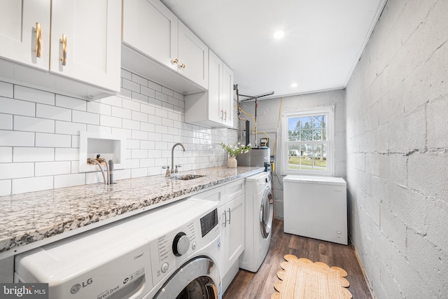 laundry room with washing machine and clothes dryer, cabinets, sink, and dark wood-type flooring