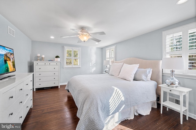 bedroom with multiple windows, ceiling fan, and dark wood-type flooring