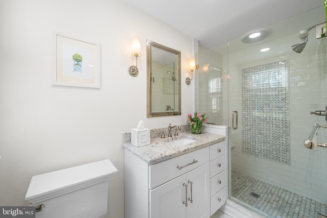 bathroom with vanity, toilet, and a shower with shower door