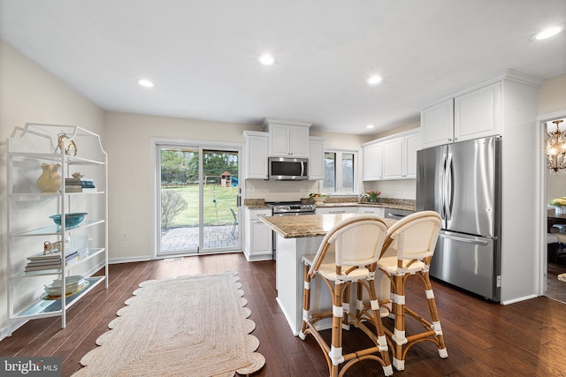 kitchen featuring white cabinets, appliances with stainless steel finishes, dark hardwood / wood-style floors, and a kitchen island