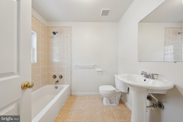 bathroom with toilet and tiled shower / bath