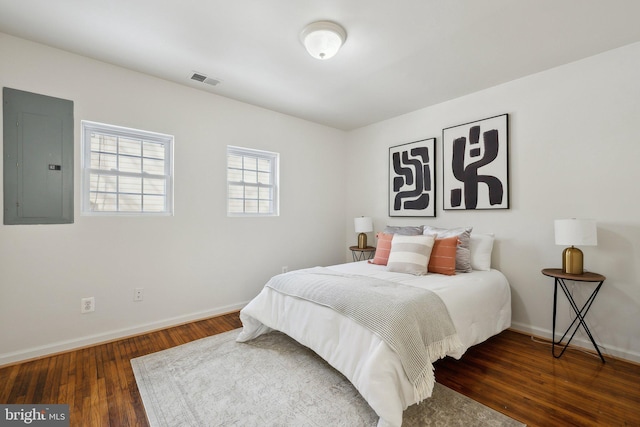 bedroom featuring electric panel and dark hardwood / wood-style floors