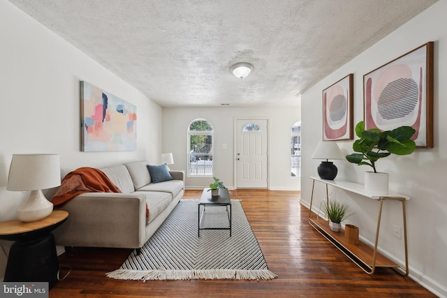 living room featuring a textured ceiling and dark hardwood / wood-style floors