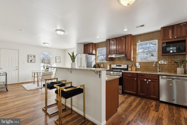 kitchen featuring appliances with stainless steel finishes, a kitchen island, a wealth of natural light, and sink