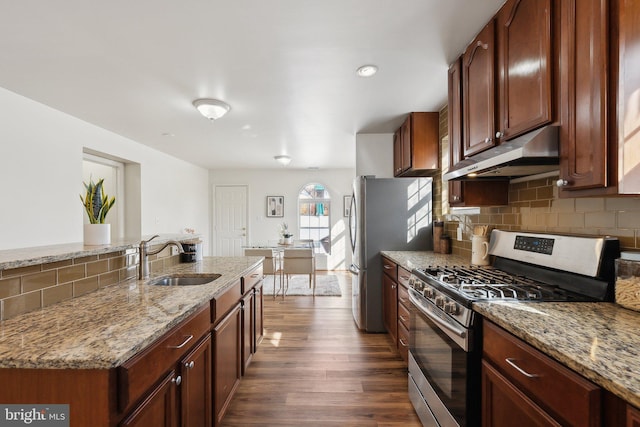 kitchen with dark hardwood / wood-style flooring, light stone countertops, sink, and appliances with stainless steel finishes