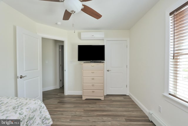 bedroom with ceiling fan, dark hardwood / wood-style floors, a wall mounted air conditioner, and a baseboard heating unit