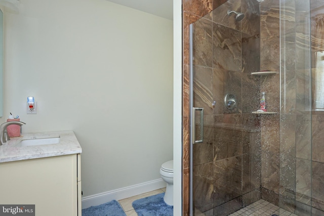 bathroom featuring tile patterned floors, vanity, toilet, and a shower with door