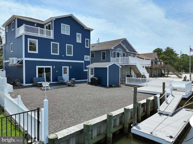 rear view of house with a balcony, a storage shed, and a wooden deck