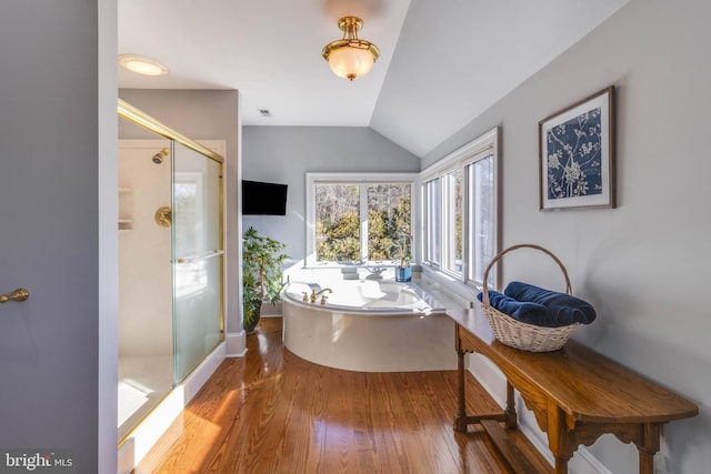 bathroom with plus walk in shower, vaulted ceiling, and hardwood / wood-style flooring