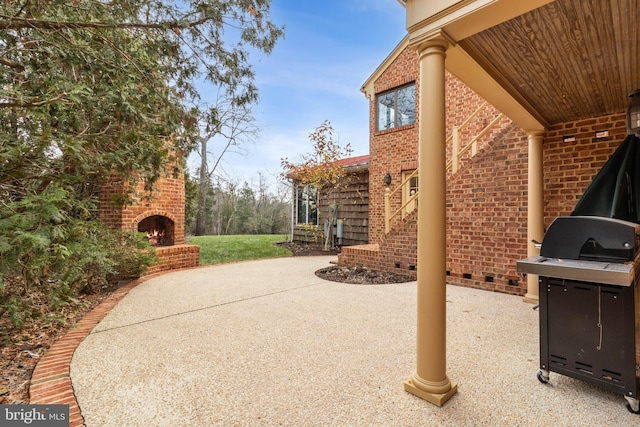 view of patio with an outdoor brick fireplace