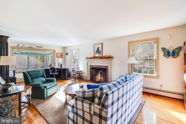 living room with a fireplace, wood-type flooring, plenty of natural light, and baseboard heating