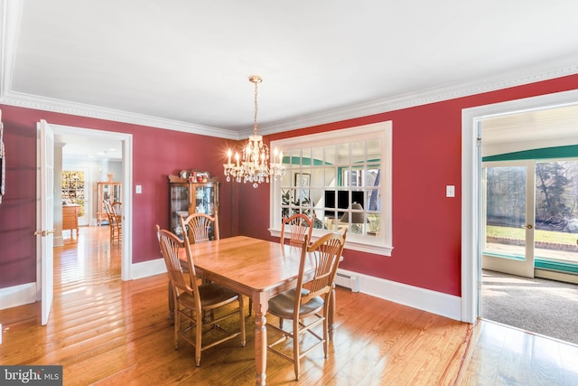 dining room featuring hardwood / wood-style floors, crown molding, plenty of natural light, and a baseboard heating unit