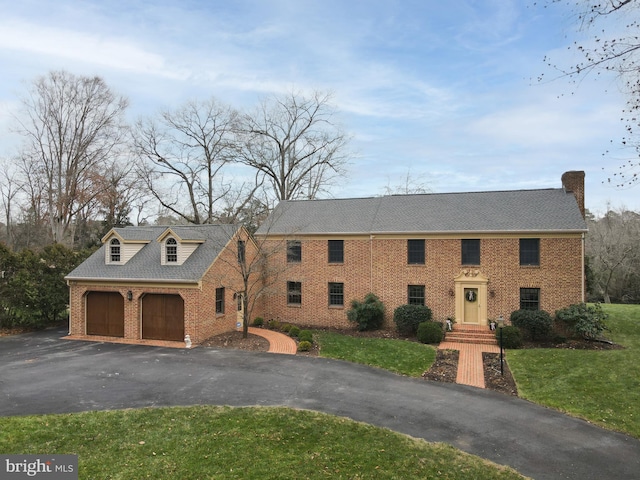 view of front of property featuring a garage and a front lawn