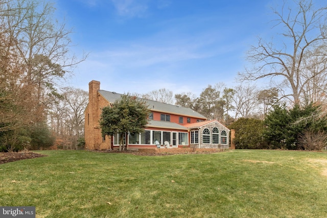 back of property featuring a yard and a sunroom