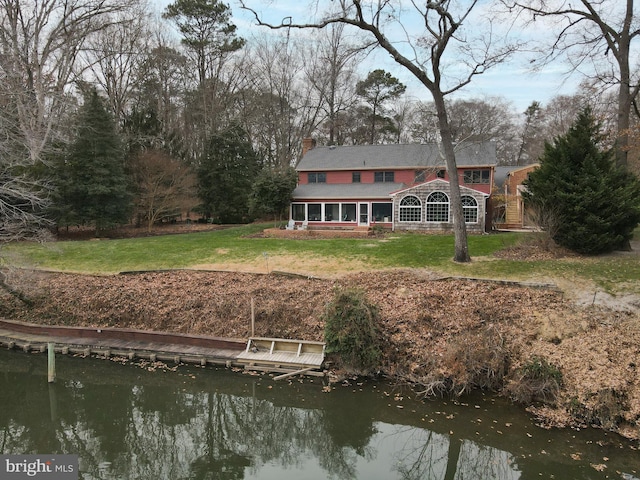 back of property featuring a yard and a water view