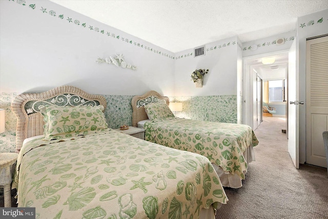 carpeted bedroom with a textured ceiling and a closet