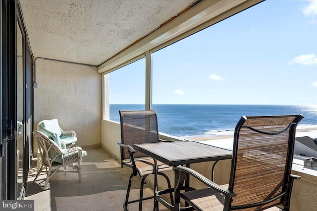 balcony featuring a beach view and a water view