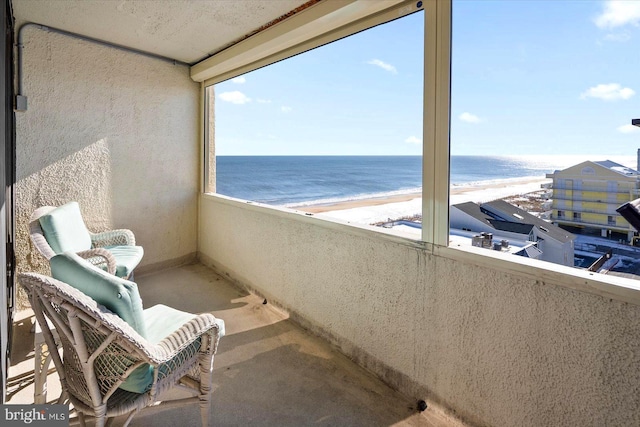 balcony featuring a beach view and a water view