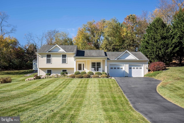 tri-level home featuring driveway, a front lawn, roof with shingles, and an attached garage