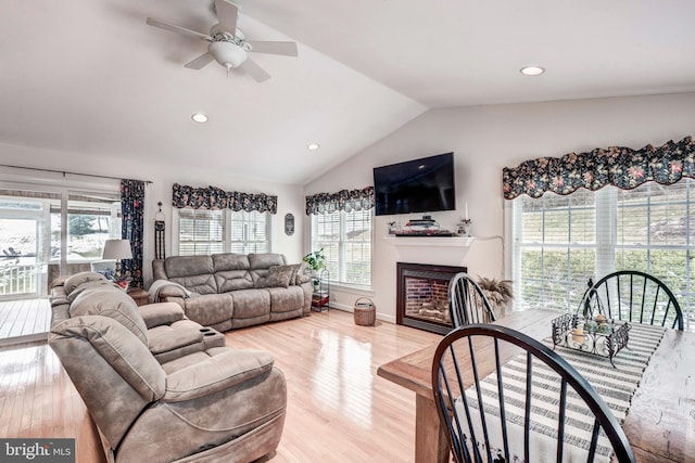 living area with a fireplace, lofted ceiling, recessed lighting, and wood finished floors