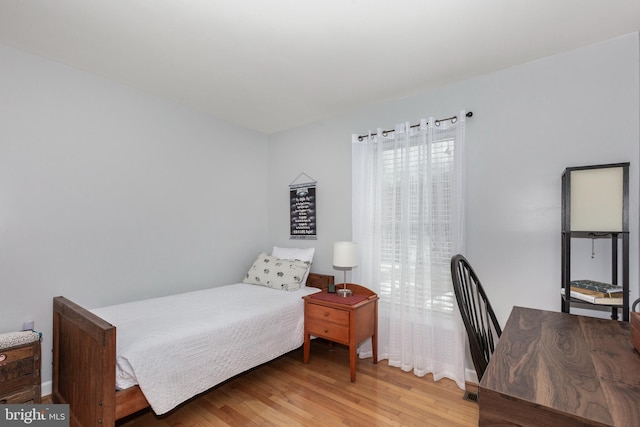 bedroom with baseboards and wood finished floors