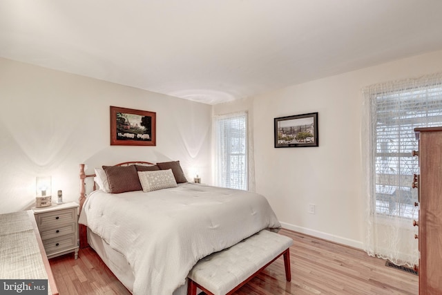 bedroom featuring visible vents, baseboards, and light wood-style flooring