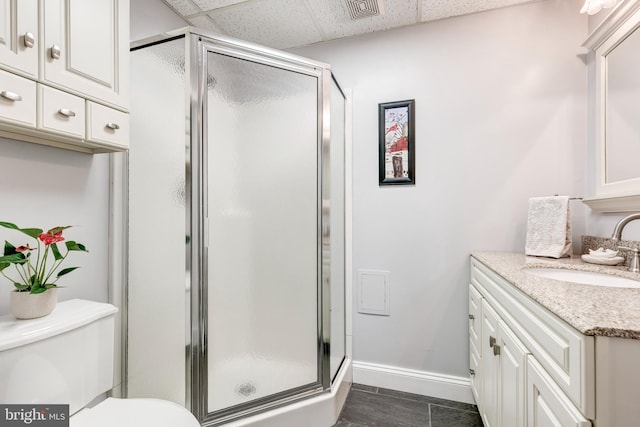 full bath featuring visible vents, baseboards, vanity, and a shower stall