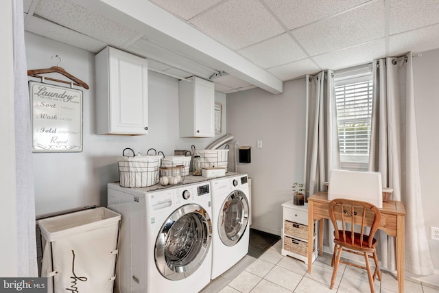 washroom featuring light tile patterned flooring, cabinet space, baseboards, and washer and clothes dryer