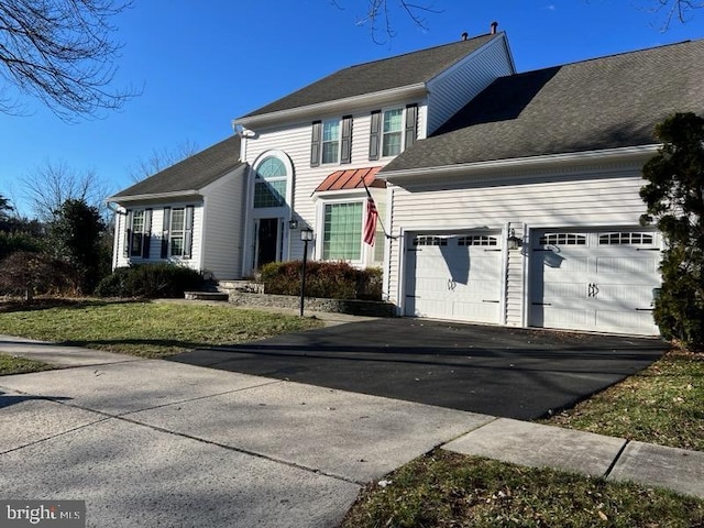 view of front of property featuring a garage and a front lawn