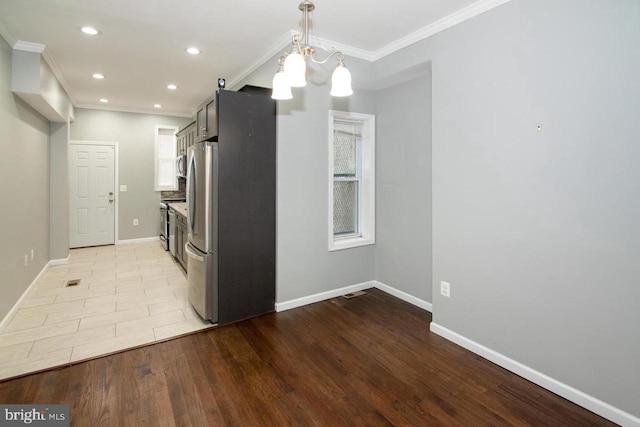 kitchen with pendant lighting, light hardwood / wood-style floors, ornamental molding, and an inviting chandelier