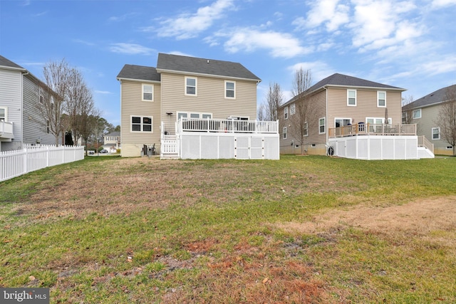 rear view of house featuring a lawn and an empty pool