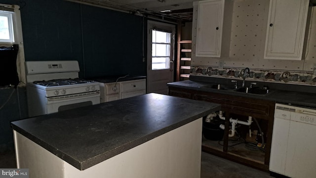 kitchen featuring white cabinets, white appliances, a kitchen island, and sink