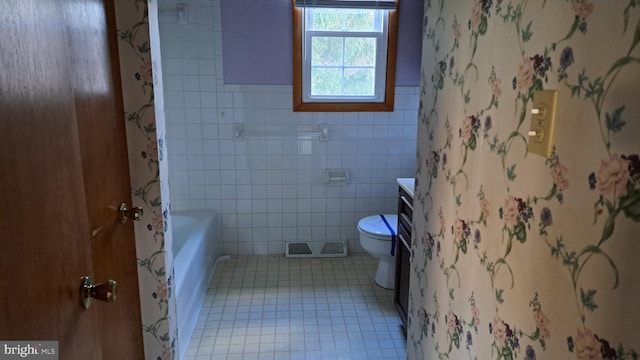 bathroom featuring vanity, toilet, and tile walls