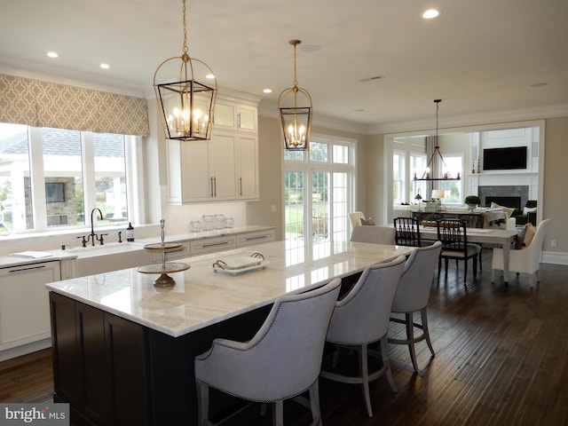 kitchen with a center island, light stone countertops, sink, and a tile fireplace