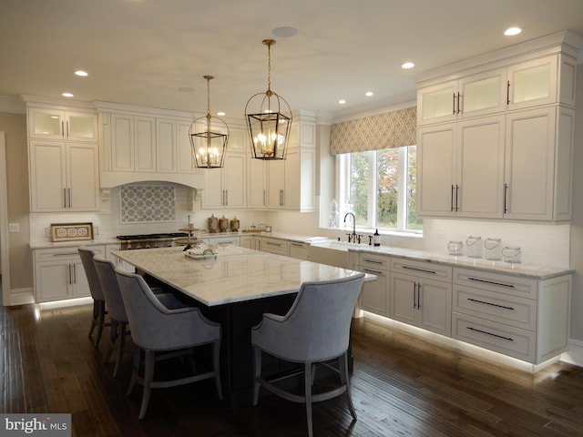 kitchen with white cabinetry, a kitchen island, dark wood-type flooring, and decorative light fixtures