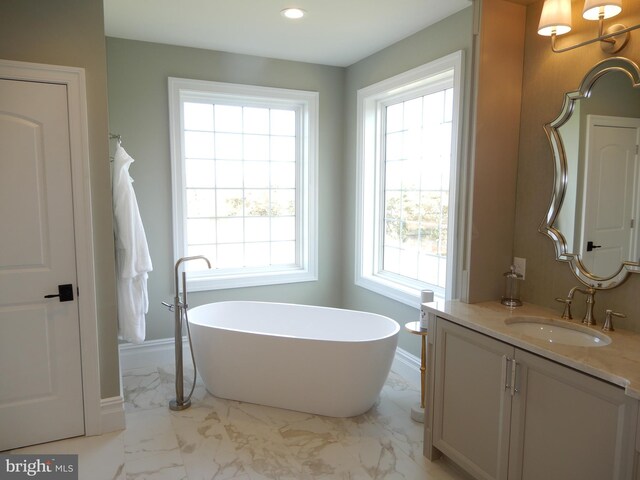 bathroom featuring a washtub and vanity