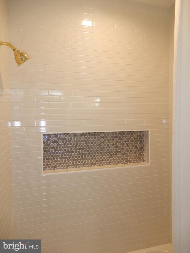 interior details featuring a tile shower