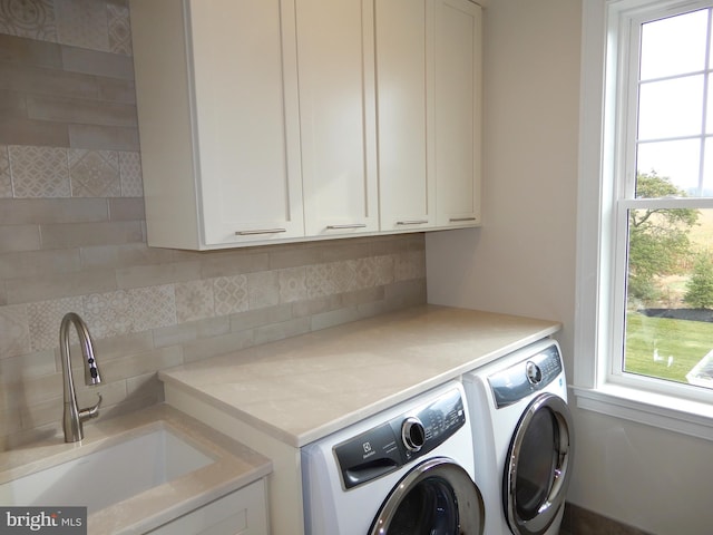 washroom featuring cabinets, separate washer and dryer, and sink