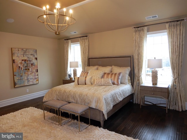 bedroom featuring a chandelier and dark wood-type flooring