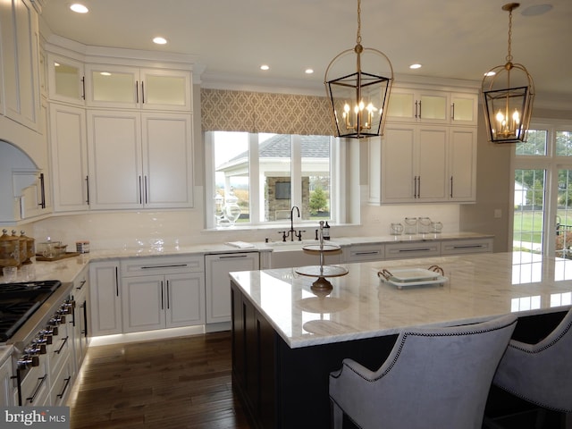 kitchen featuring decorative light fixtures, a kitchen island, and light stone counters