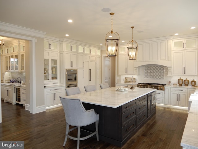 kitchen with a center island, beverage cooler, a kitchen breakfast bar, backsplash, and decorative light fixtures