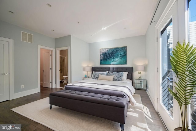 bedroom featuring dark hardwood / wood-style flooring and ensuite bath