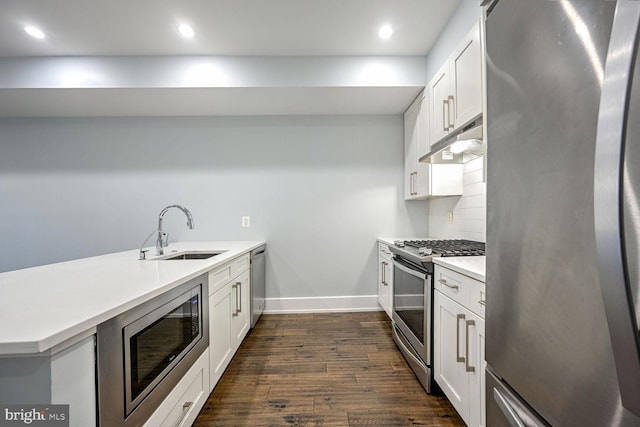 kitchen featuring white cabinets, appliances with stainless steel finishes, decorative backsplash, and sink