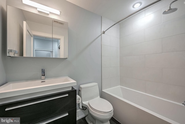 full bathroom featuring toilet, vanity, and tiled shower / bath combo