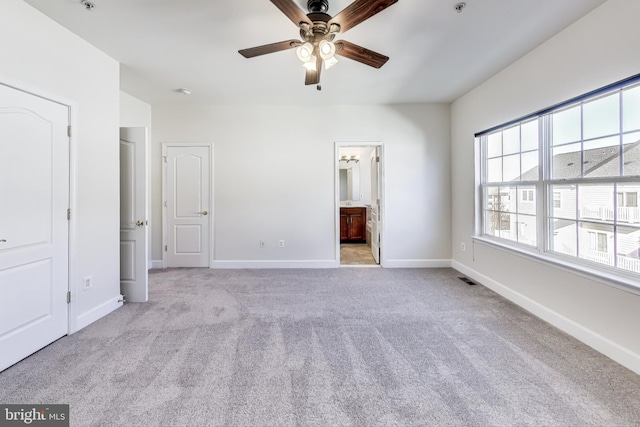 unfurnished bedroom with connected bathroom, ceiling fan, and light carpet