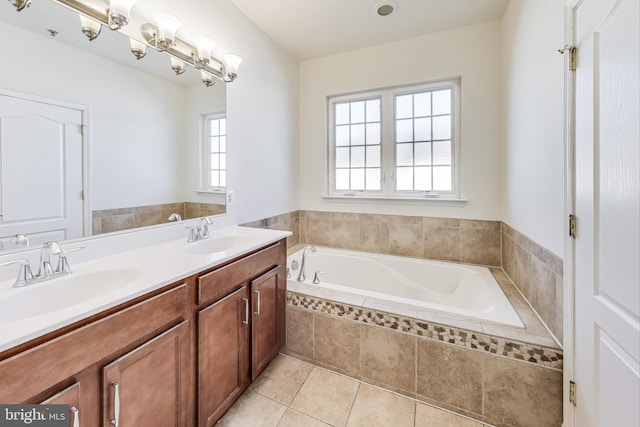 bathroom featuring tile patterned flooring, vanity, and a relaxing tiled tub