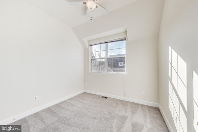 empty room featuring light carpet, ceiling fan, and lofted ceiling